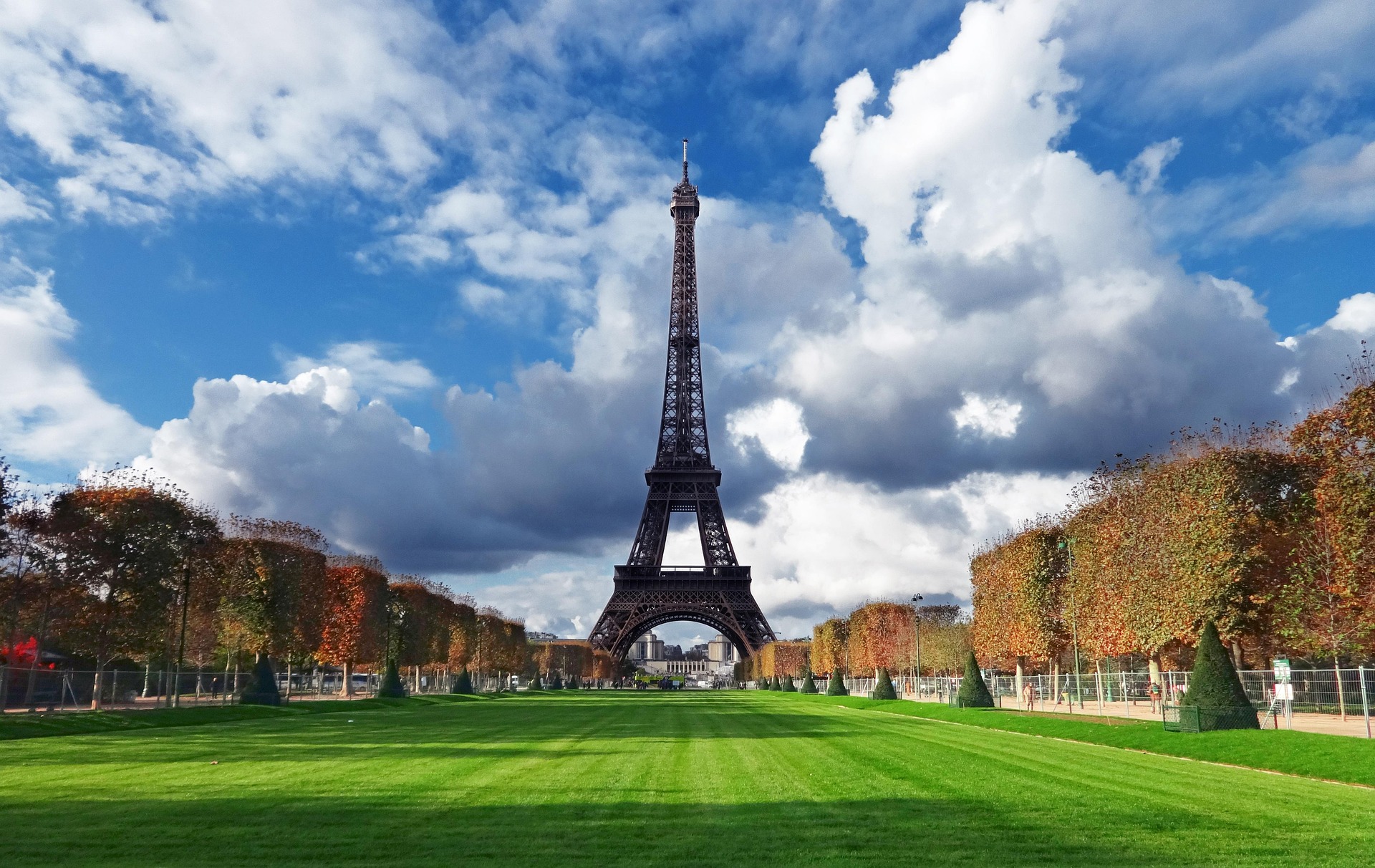 Chipway au SymfonyCon Paris 2015. Tour Eiffel sous un ciel nuageux, entourée de verdure et d'arbres d'automne.