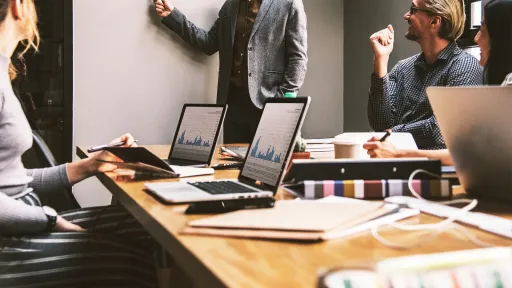 conseil digital en Réunion d'équipe en salle, ordinateurs portables ouverts.