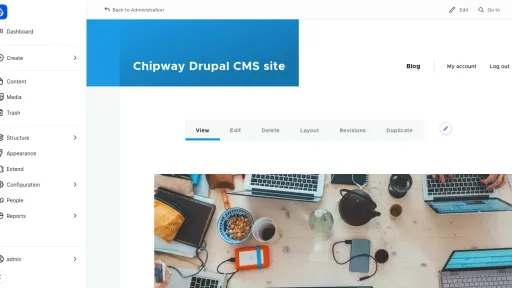 Interface Drupal CMS avec un menu latéral gauche et une image d'ordinateurs sur une table.